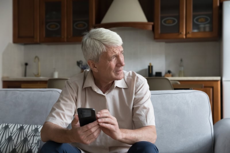 What’s That Smell Coming From My Furnace? Worried senior smartphone user getting bad, concerning news message, holding mobile phone, looking away, feeling stressed, anxious, thinking over problems.